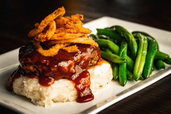 Not your ordinary meatloaf! A special blend of ground veal and beef, topped with our house made BBQ gravy and frazzled onions. Served with fresh, sautéed green beans & Yukon Gold mashed potatoes. 