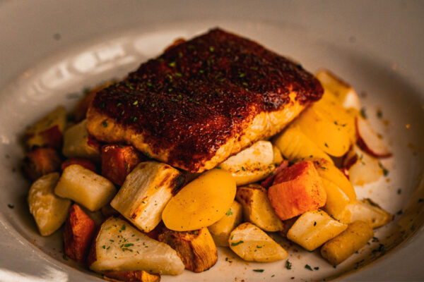 Atlantic salmon filet seasoned with warm North African spices and grilled to perfection. Served with a medley of root vegetables, zucchini & tomatoes.