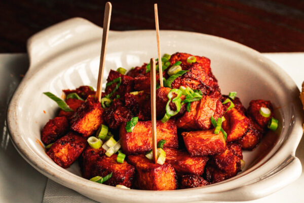 Crispy, deep-fried pork belly bites. Served tossed in your choice of any of our house made sauces. Topped with fresh chopped scallions.